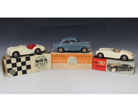 Three V Models plastic and battery powered cars, comprising a Triumph TR2 Sports and an MGA, both finished in white, and a Va