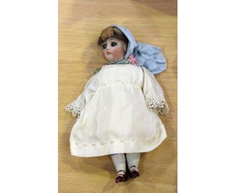 A German bisque doll's house doll with brown wig, painted features and jointed body, height approx 13cm, together with a doll