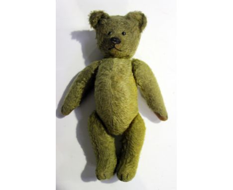 An early/mid-20th Century humpback mohair teddy bear with boot button eyes, stitched snout and jointed body with felt pads an