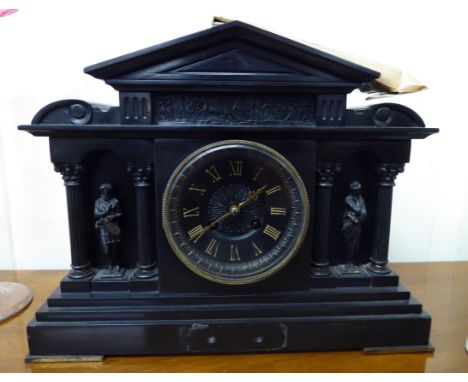 A 1930s black slate cased mantel clock; the movement faced by a gilded Roman dial, raised on a stepped bracket plinth  12''h 