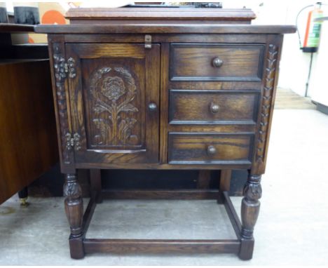 A Jaycee stained oak cupboard with a carved panelled door and three drawers, raised on bulbous legs  29''h  25''w       RAM