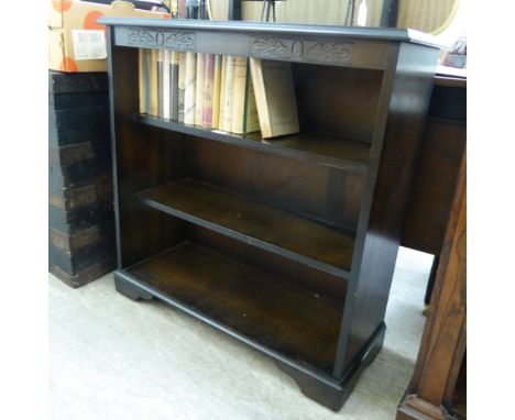 A modern stained and carved oak open front three-tier bookcase, raised on bracket feet  32''h  72''w       RAM