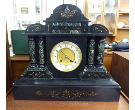 A 1930s black slate mantle clock of architectural form; the movement faced by a white enamel Roman dial, on a plinth  14.5''h