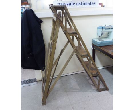 An early 20thC Hatherley Patent, stained wooden, four tread step ladder, raised on block feet       SR