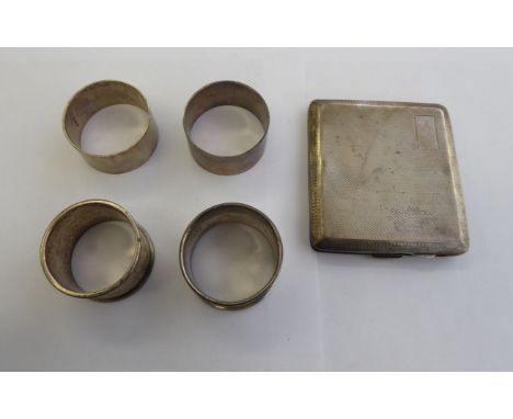 A pair of silver plain band napkin rings; two dissimilar; and a folding silver cigarette case with engine turned decoration  