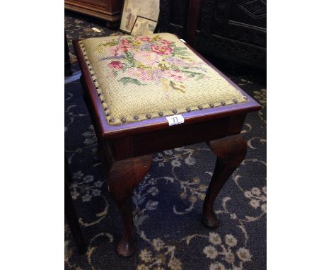 An early 20th century mahogany piano stool with lift-top tapestry covered seat.