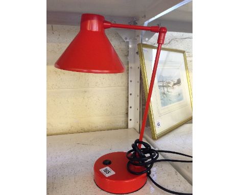 A red Habitat metal angle poise table lamp.