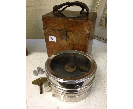 A pigeon racing timing clock in original wooden case.