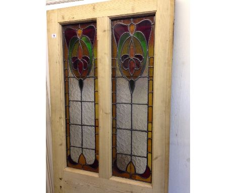 An early 20th century pine door with Art Nouveau leaded coloured glass window panels.