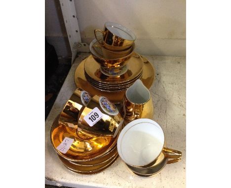 A Czechoslovakian gold china tea service decorated with panels of classical female figures in the Kaufmann style.