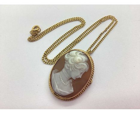 A 9ct Gold Carved Cameo Brooch / Pendant, the oval panel depicting the side portrait of a lady, within ropetwist style surrou