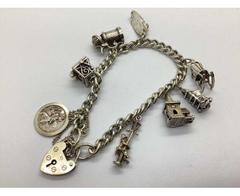 A Hallmarked Silver Curb Link Charm Bracelet, suspending assorted novelty charms, to include articulated tankard, souvenir, S