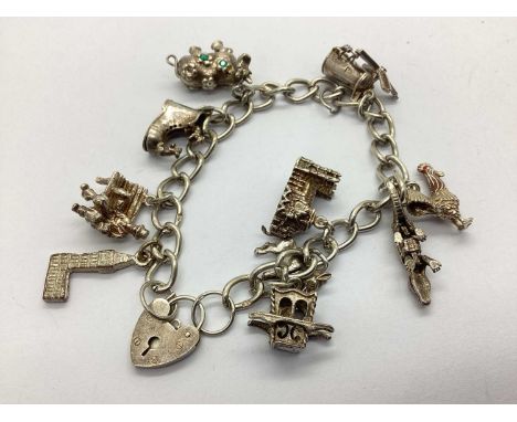 A Hallmarked Silver Curb Link Charm Bracelet, suspending assorted novelty charms, including articulated aligator, enamelled c