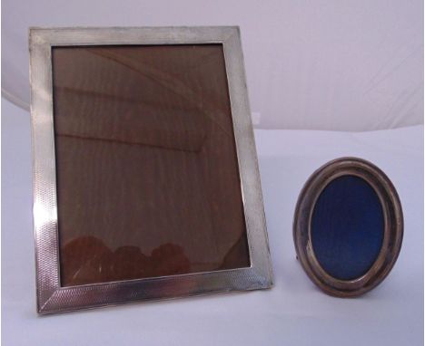 A hallmarked silver engine turned photograph frame of rectangular form and a hallmarked silver oval photograph frame
