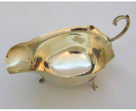 A hallmarked silver sauce boat with flying double scroll handle on three pad feet, marks rubbed, approx total weight 87g