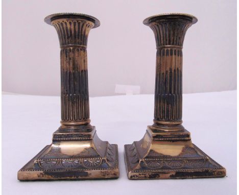 A pair of late Victorian hallmarked silver table candlesticks with fluted stems on raised square bases, 14cm (h)