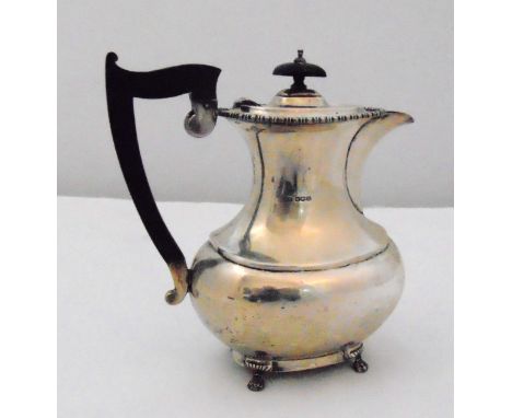 An Edward Viner hallmarked silver coffee pot of waisted rounded rectangular form with angled ebonised wooden handle on four c