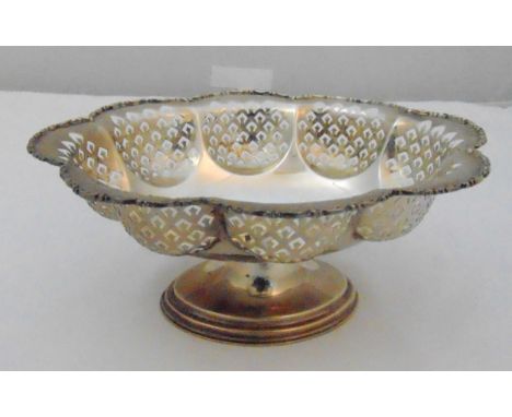 A hallmarked silver fruit bowl of shaped circular form with scroll pierced sides on raised oval base, Chester 1928, approx to