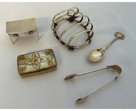 A quantity of hallmarked silver and white metal to include a pair of sugar tongs, a teaspoon, a stamp box in the form of a mi