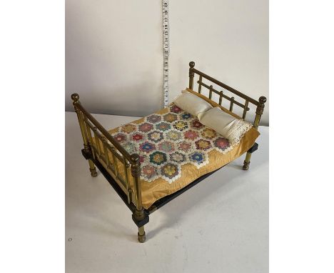 A antique brass and cast iron dolls bed compete with handmade welsh quilt and pillows 50x5cm, shipping unavailable