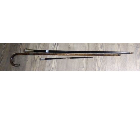 A silver mounted ebony conductor's baton, a silver topped ebonised walking stick and a silver mounted cane.  