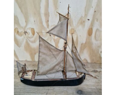 A scratch built wooden model of a sailing barge.  