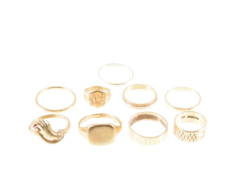 Nine 9 carat yellow gold rings, wedding and signet rings and one ring in the from of a hand, most in a slightly worn conditio