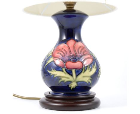 A Moorcroft table lamp, "Anenome" pattern on blue ground complete with cream shade.