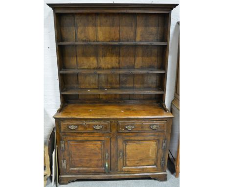 Joined oak dresser, cavetto moulded cornice, panelled back with three fixed shelves, the base with a rectangular top, moulded