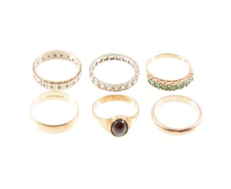 Six various rings, a seven stone emerald half eternity ring in 9 carat yellow gold ring size Q, an oval garnet cabochon ring,