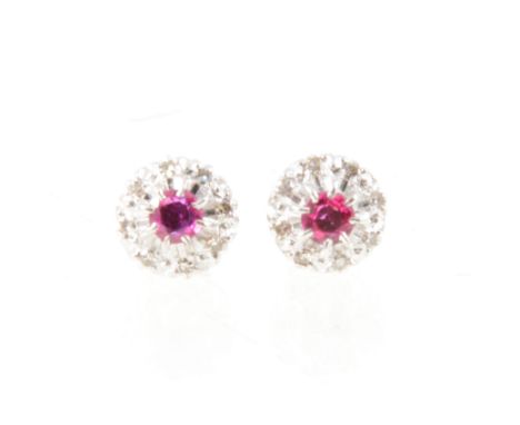 A pair of ruby and diamond earstuds, a circular brilliant cut ruby surrounded by eight small diamonds in all white metal moun