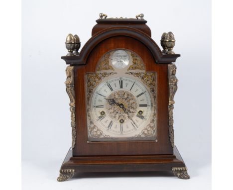 A reproduction stained wood bracket clock, with metal appliques, arched dial signed Urgos, movement striking on five gongs, 3