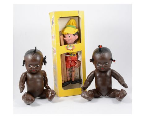 Pair of black dolls and Pinocchio pelham puppet.