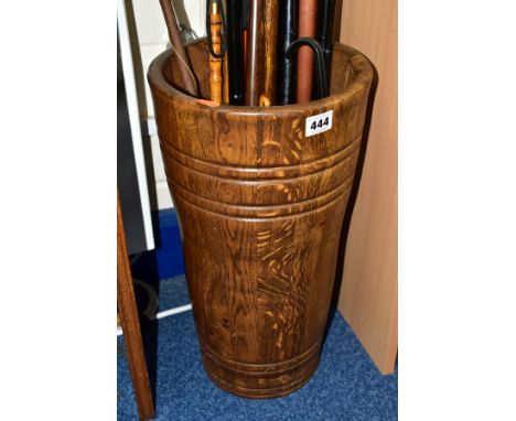 AN OAK STICK STAND OF PANELLED FORM, height 46cm, containing a back scratcher, a large wooden ornamental pipe, nine various w