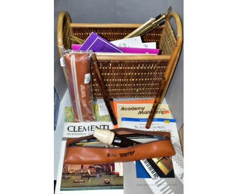 A WICKER MAGAZINE RACK CONTAINING MUSIC RELATED ITEMS, to include an Aulos Tenor recorder with soft case, a Aulos alto record