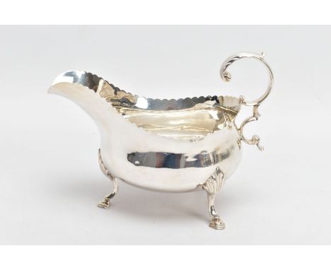 A GEORGE III SILVER GRAVY BOAT, with scalloped edge, scrolling handle and raised on step pad feet, silver hallmark for London