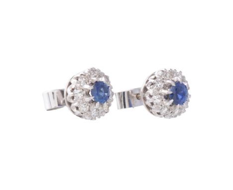 
	
		A pair of sapphire and diamond cluster ear studs, centrally set with a circular mixed cut sapphire within a surround of 