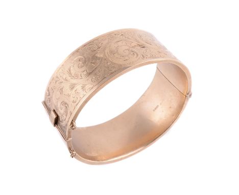 
	
		A 9 carat gold hinged bangle, with foliate engraved top and polished base, hallmarked Birmingham 1968, 35.4g
		
		Condit
