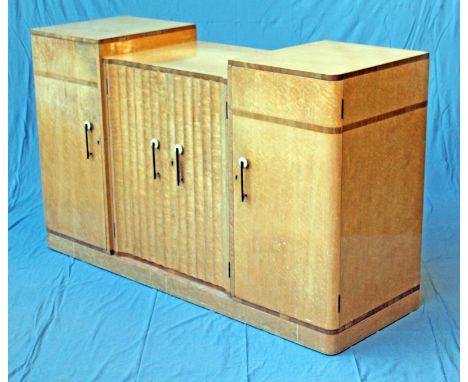 An Art Deco bird's eye maple sideboard attributed to Harry & Lou Epstein having stepped top above ribbed central cupboard fit