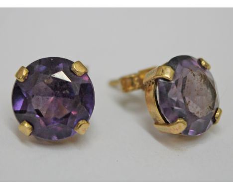 A pair of yellow metal amethyst stud earrings, each stone approx.. diam. 10mm, depth 4mm, gross wt. 3.9g.