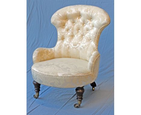 A Gillows Lancaster button back nursing chair with mahogany legs and brass castors, each back leg stamped 'Gillow'. W60cm D73