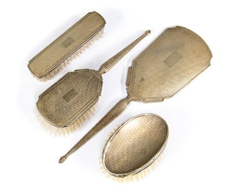 An Art Deco style engine turned matched silver dressing table set, comprising mirror and three various brushes, Charles S Gre