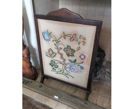 An early 20th Century oak firescreen, depicting a floral scene, 77cm high, 52cm wide