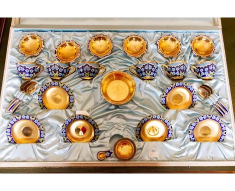 A Russian silver-gilt and champleve enamel six piece tea set, comprising: sugar bowl, tea strainer,&nbsp;six cups, saucers an