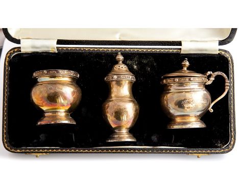An Elizabeth II silver three-piece cruet, comprising mustard, open salt&nbsp;and pepper, blue glass liners,&nbsp;stylised dra