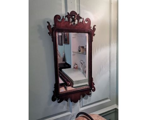 A George II style walnut wall mirror, in the Baroque manner, eagle carved finial, scrollwork design, 89cm high, 47cm wide