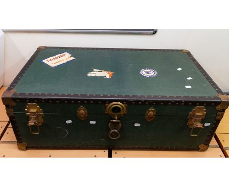 A steamer trunk in dark green with black banding, Cunard stickers to top, light checked interior, along with a wicker picnic 
