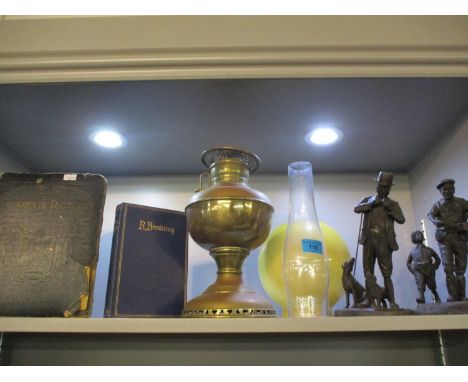 Two composition figures and an early 20th century oil lamp with yellow shade, a Robert Browning poetry book and a cigarette c
