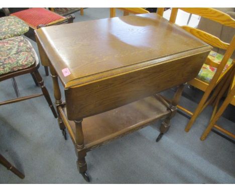 A mid 20th century dark elm tea trolley having inset drawer and shelf below 