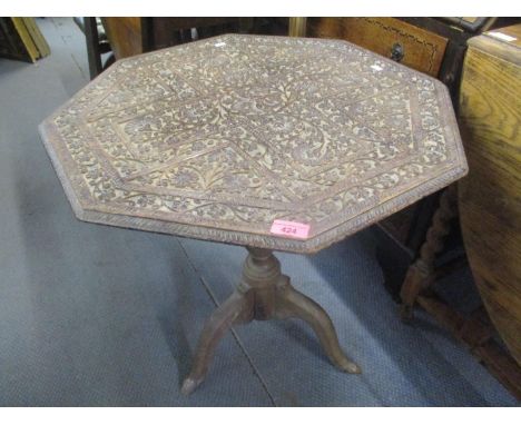 A 19th century occasional table having a heavily carved, floral top and a tripod base 